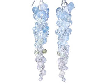 May include: A pair of long, silver dangle earrings with a cluster of light blue, green, and white gemstones.