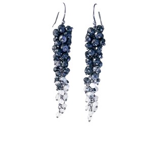 May include: A pair of long, dangling earrings with a gradient of black and white beads. The earrings are made of metal and have a hook closure.