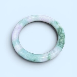 May include: A smooth, circular bangle bracelet crafted from polished stone, featuring a marbled pattern with soft lavender and light green hues blended throughout the material, creating a continuous, solid, and rounded band design.