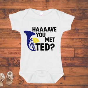 May include: White baby onesie with a blue and yellow french horn and the text "HAAAAVE YOU MET TED?"
