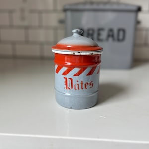 May include: A vintage enamelware canister with a red and white striped design. The canister has a lid and says "Pâtes" in red lettering.