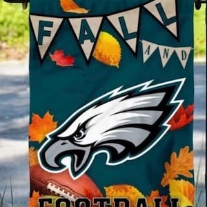 May include: A teal garden flag featuring a white eagle head logo, a brown football, and scattered autumn leaves. The text "FALL" is displayed on a white pennant banner, and the word "FOOTBALL" is printed in black block letters at the bottom.