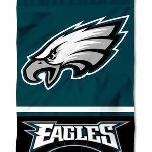 Könnte beinhalten: Eine teal- und schwarze Gartenflagge mit dem Logo der Philadelphia Eagles. Der obere Teil zeigt das Adlerkopf-Logo des Teams in Weiß und Grau. Der untere Teil trägt das Wort "EAGLES" in Weiß, umrandet in Schwarz.