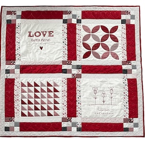 Może przedstawiać: Kołdra w kolorze czerwonym i białym z czterema kwadratami. Każdy kwadrat ma inny wzór. Lewy górny kwadrat zawiera napis "LOVE lives here". Prawy górny kwadrat ma czerwony i biały wzór geometryczny. Lewy dolny kwadrat ma czerwony i biały wzór trójkątów. Prawy dolny kwadrat ma czerwony i biały wzór kwiatowy i zawiera napis "love one another".