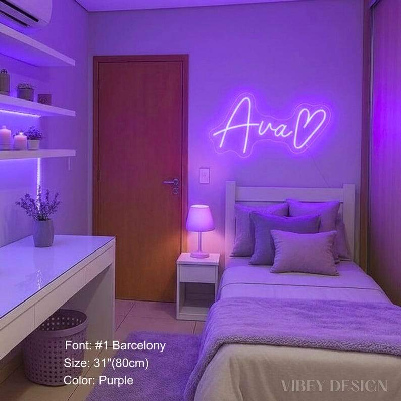 K&ouml;nnte beinhalten: Ein violettes Neonschild mit dem Namen Ava und einem Herzsymbol in Schreibschrift. Das Schild ist an einer Wand &uuml;ber einem Bett montiert. Der Schriftzug ist 80 cm breit. Die allgemeine Beleuchtung des Raumes ist violett und leuchtend.
