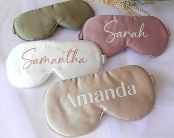 May include: Four personalized sleep masks in different colors. The masks are made of satin and have names embroidered on them: Samantha, Amanda, Sarah, and KS.