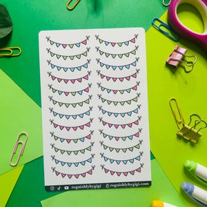 May include: A sheet of stickers with multiple rows of colorful bunting flags. Each row has a different color combination of pink, green, blue, and white. The stickers are on a white background and have a white border. The text "roguishlybygigi" is at the bottom of the sheet.