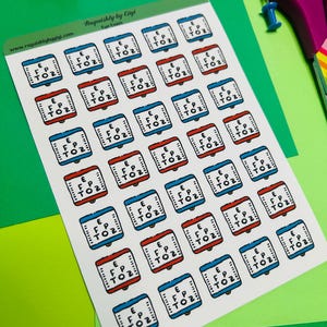 May include: Sheet of stickers featuring eye exam charts in red and blue frames. The stickers have the text "E FP TOZ" on them. The sheet also has the text "Roguishly by Gigi" and "Eye Exam".