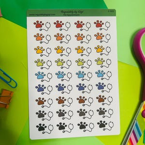 May include: Sheet of stickers featuring colorful paw prints paired with stethoscopes. The stickers are in various colors, including red, orange, yellow, green, blue, brown, and black. The text "Roquishly by Gigi Pet Appointment" is at the top.