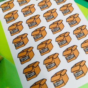 Puede incluir: Una hoja de pegatinas con múltiples ilustraciones de cajas de cartón abiertas en color naranja con contornos negros. Cada caja tiene la palabra DONATE impresa en el frente en una etiqueta rectangular. El texto Roguishly by Gigi Donate Box está en la parte superior.