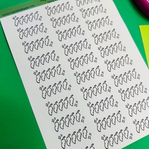 May include: A sheet of stickers featuring a repeating pattern of black chili pepper illustrations with a sparkling effect. The text "Roguishly by Gigi" and "Spicy Rating" is visible. The background is green.