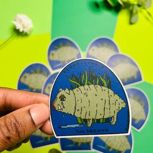 May include: A blue and green sticker with a cartoon illustration of a crying, furry creature with the text "PENNSYLVANIA" and "THE SQUOUNK" on it.