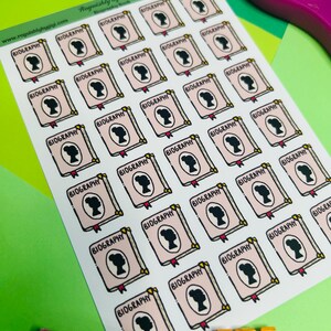 May include: A sticker sheet featuring thirty-five individual rectangular stickers, each displaying a light pink book cover with a black silhouette of a person's head and the word BIOGRAPHY printed in black capital letters at the top.
