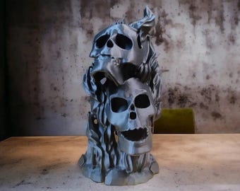 Könnte beinhalten: Eine 3D-gedruckte Skulptur aus drei Schädeln, die übereinander gestapelt sind, wobei der oberste Schädel Hörner hat. Die Skulptur ist aus einem dunkelgrauen Material gefertigt und hat eine strukturierte Oberfläche.