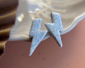 May include: A pair of silver glitter lightning bolt earrings.