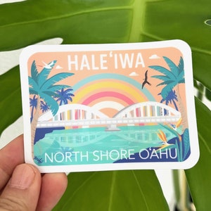 May include: A sticker with a colorful illustration of a bridge over a body of water. The text "HALE'IWA NORTH SHORE O'AHU" is printed on the sticker.