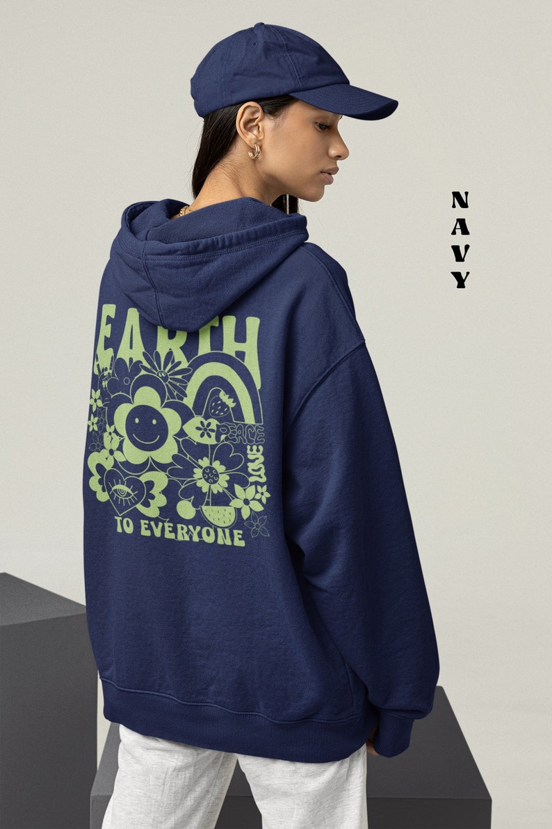 May include: A navy blue hooded sweatshirt with a green graphic on the back that says "Earth Peace Love To Everyone" with a smiley face and flowers.