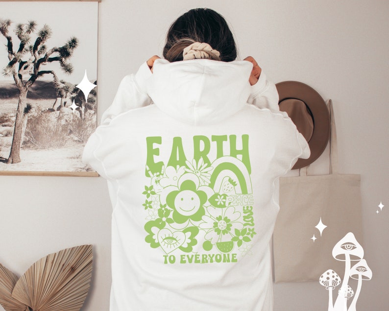 May include: White hoodie with a green graphic print on the back that says "EARTH TO EVERYONE" with a flower and rainbow design.