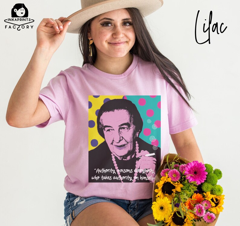 May include: A lilac t-shirt with a pop art style image of a woman with a quote: "Authority poisons everybody who takes authority on himself."