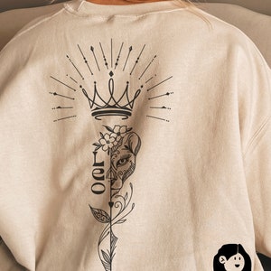 May include: A beige sweatshirt with a black graphic design on the back. The design features a crown, a lion's face, and the word "Leo" in a stylized font.