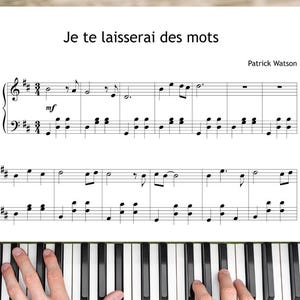 May include: A piano keyboard with black and white keys, with sheet music on top. The sheet music has the title "Je te laisserai des mots" and the composer's name, Patrick Watson. Hands are playing the piano.