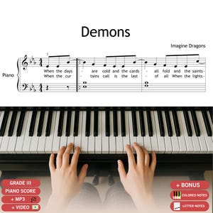 Puede incluir: Partitura de piano de la canción "Demons" de Imagine Dragons. La partitura se muestra encima de un teclado de piano, con manos tocando las teclas. El texto "GRADE III PIANO SCORE" es visible.