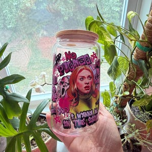 Puede incluir: Un tarro de cristal transparente con tapa de bambú, con un diseño gráfico con el texto "No Please" y "I Wanna Be In The Scene". El diseño incluye un retrato de una mujer pelirroja y una cara de fantasma.