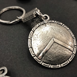 Llavero con escudo espartano, escudo del rey Leónidas con la letra griega Λ, leyenda griega antigua de los 300 espartanos, escultura de metal de arte griego antiguo