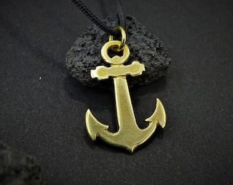 May include: A gold-colored anchor pendant necklace with a black cord. The anchor is detailed with a loop at the top and a crossbar.