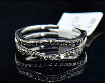 May include: A silver ring with a black diamond band. The ring is a double band with a curved design.