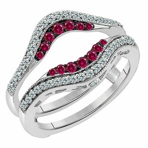 May include: A silver ring with a curved design, featuring a row of small red gemstones and a row of smaller white gemstones.