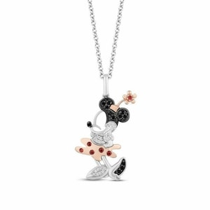 May include: A silver necklace with a black and white diamond Minnie Mouse pendant. The pendant features red accents and a small flower.