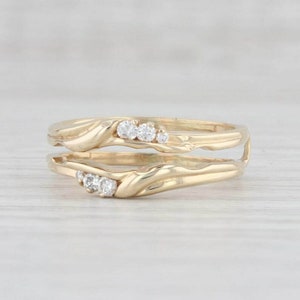 Puede incluir: Un anillo de oro con engaste de diamantes. El anillo está diseñado para ser usado como un realzador de banda de boda.