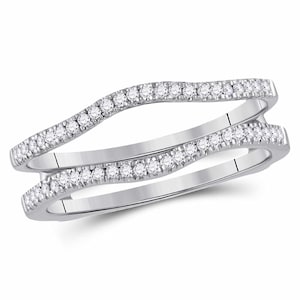 May include: A silver ring with a wavy design and small diamonds set in the band. The ring is designed to be worn as a wedding band enhancer.