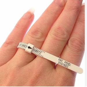 May include: White plastic ring sizer with black markings and an arrow. The sizer is labelled with letters from "J" to "Z" and the text "PAT. PEND. 9101693".
