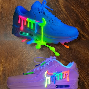 May include: A white ceramic mug with a black handle and the text "But First, Coffee" in a bold, black font. The mug is set against a blurred background, suggesting a cozy setting.