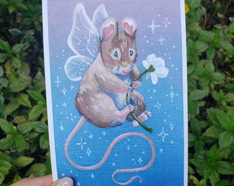 May include: A watercolor painting of a brown mouse with fairy wings holding a white flower. The mouse has pink ears and a pink tail. The background is a blue gradient with white stars.
