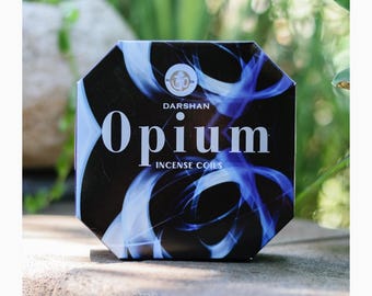 May include: A black and blue box with the text "Darshan Opium Incense Coils" on it. The box has a design of blue smoke on a black background.