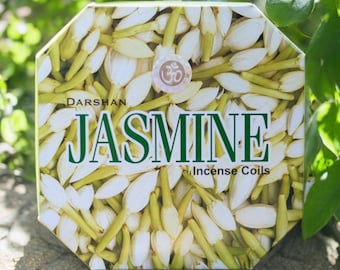 Könnte beinhalten: Eine Schachtel Darshan Jasmine Räucherstäbchen. Die Schachtel ist weiß mit grünem Text und einem floralen Design. Der Text auf der Schachtel lautet "Darshan Jasmine Incense Coils".