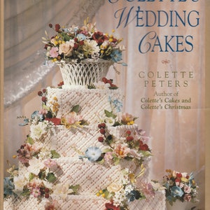 May include: A multi-tiered wedding cake decorated with white fondant and intricate latticework. The cake is adorned with a variety of fresh flowers, including roses, lilies, and berries. The cake is presented on a white pedestal and is surrounded by a white background.