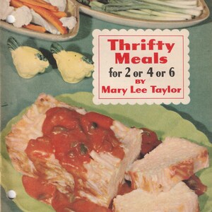 May include: A vintage cookbook cover with the title "Thrifty Meals for 2 or 4 or 6" by Mary Lee Taylor. The image features a plate of food with a red sauce, vegetables, and two yellow chicken-shaped salt and pepper shakers.