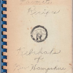 May include: A vintage cookbook titled "Favorite Recipes" with handwritten script on aged paper. The cover features a circular emblem and the text "Rebekahs of New Hampshire." The book has a blue spiral binding.