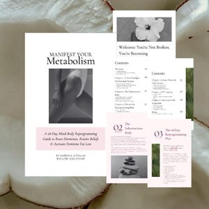 Op de afbeelding: Een stapel bedrukte pagina's, waaronder een met de titel "Manifest Your Metabolism" en de ondertitel "A 28-Day Mind-Body Reprogramming Guide to Reset Hormones, Rewire Beliefs & Activate Feminine Fat Loss." Andere pagina's tonen "Welcome: You're Not Broken, You're Becoming."