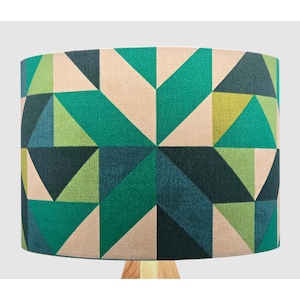 May include: A lampshade with a geometric pattern of triangles in shades of green, blue and beige.