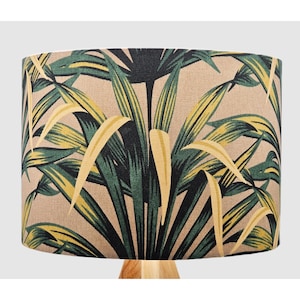 May include: A beige lampshade with a tropical leaf pattern in shades of green and yellow.