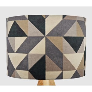 May include: A lampshade with a geometric pattern in shades of beige, grey, and black.