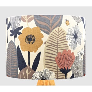 May include: A lampshade with a floral pattern featuring brown, yellow, and red flowers on a cream background. The pattern also includes stylised leaves and butterflies.