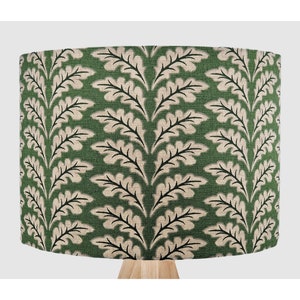 May include: A green lampshade with a beige and black oak leaf pattern.
