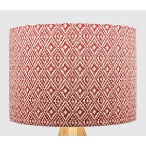 May include: A red and cream patterned lampshade with a geometric design. The lampshade is made of fabric and has a cylindrical shape.