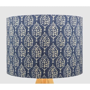 May include: A blue lampshade with a white floral pattern. The lampshade is made of fabric and has a cylindrical shape.